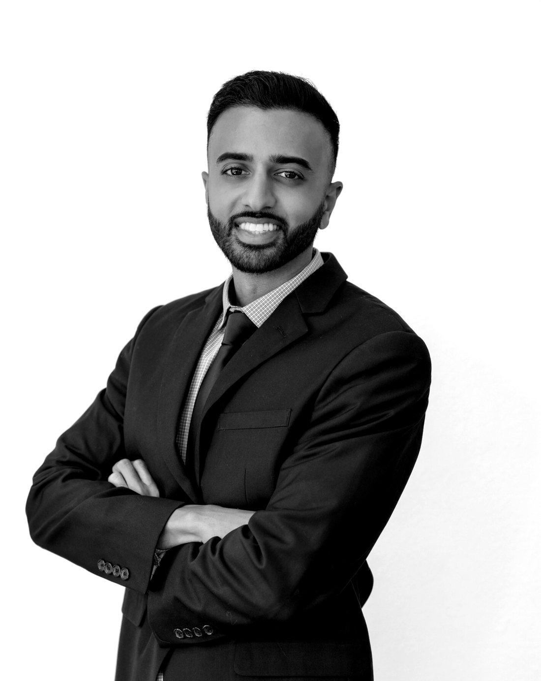 Portrait of Shoeb Ikram in a dark suit, arms crossed